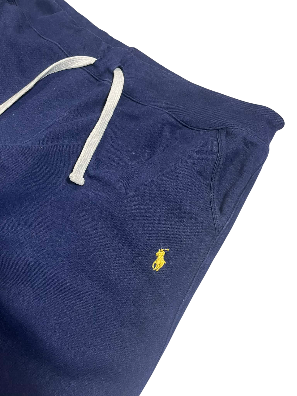 Sötétkék streetwear melegítőnadrág sárga hímzett logóval és fehér húzózsinórral