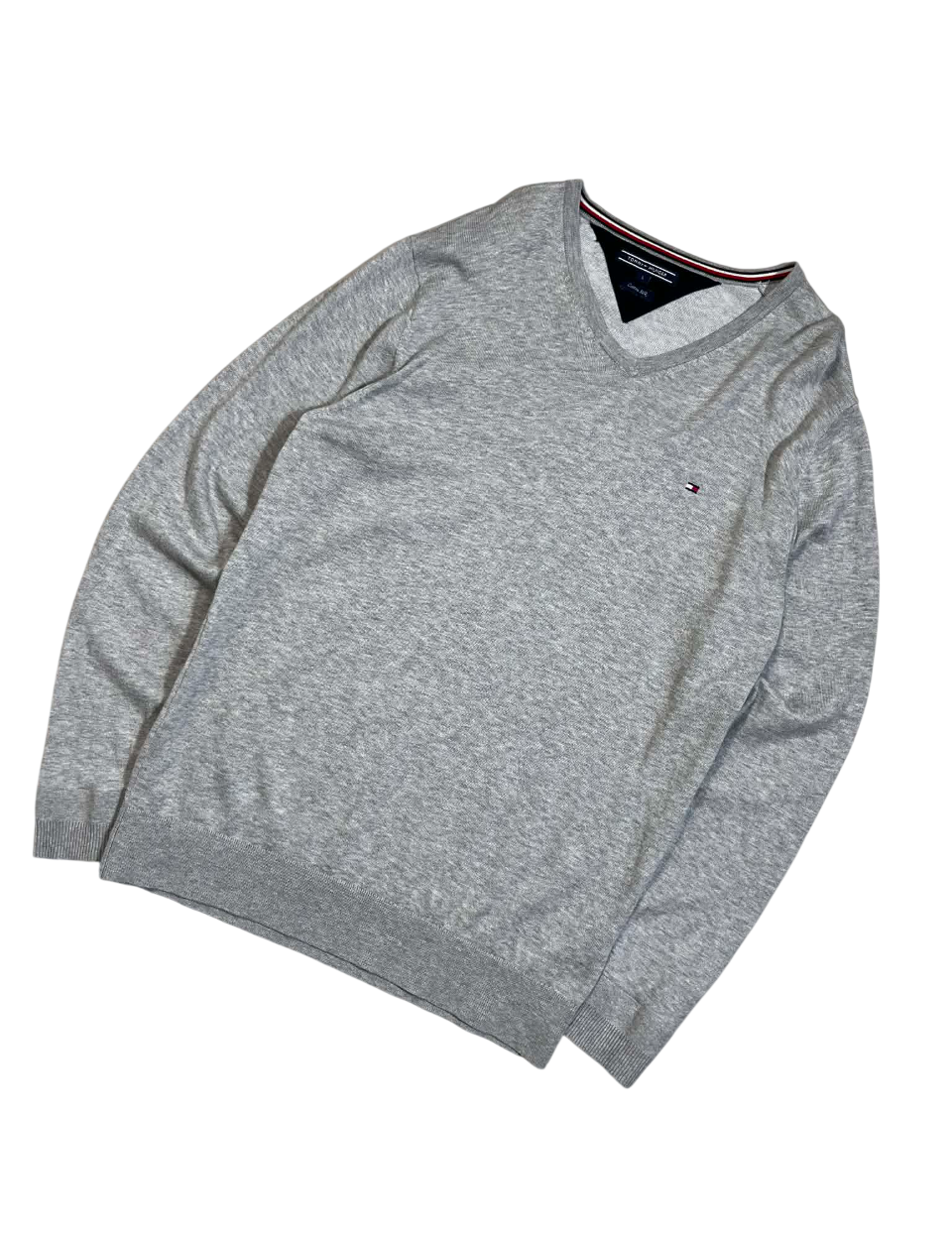 Szürke V-nyakú pulóver, hímzett logóval, vintage streetwear stílusban.