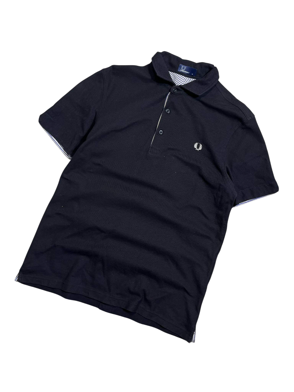 Fekete rövid ujjú vintage galléros póló fehér logóval, streetwear stílus