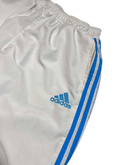 Fehér Adidas streetwear melegítőnadrág kék csíkokkal és logóval, vintage stílusban