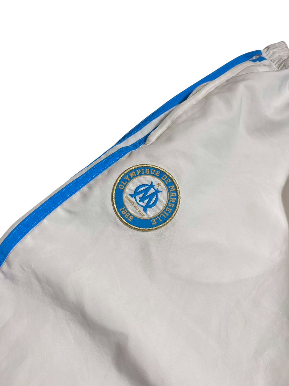 Fehér vintage sportdzseki kék szegéllyel és Olympique de Marseille címerrel