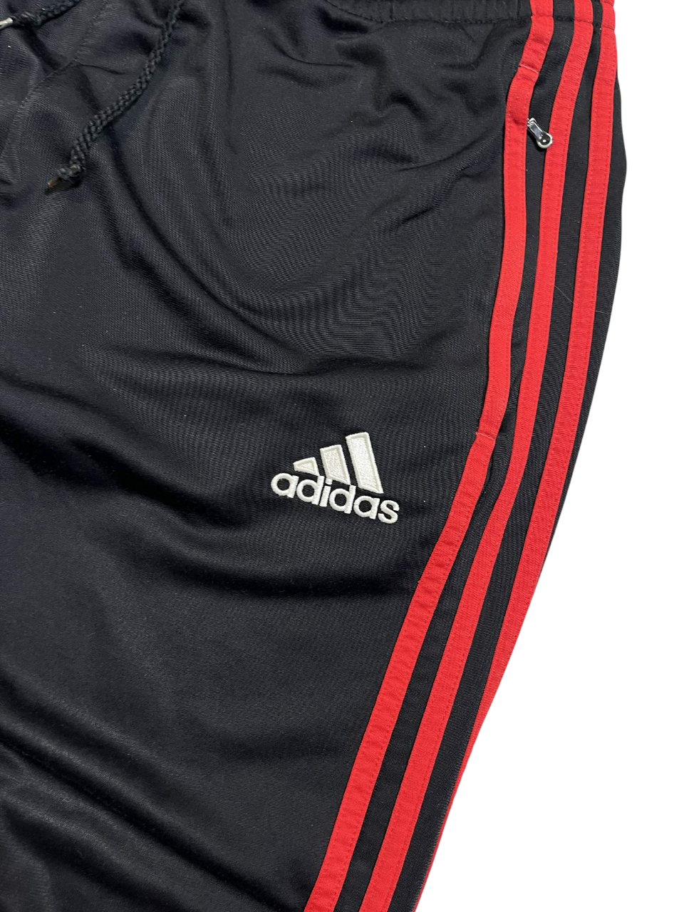 Fekete Adidas melegítőnadrág piros csíkokkal és logóval, streetwear stílus