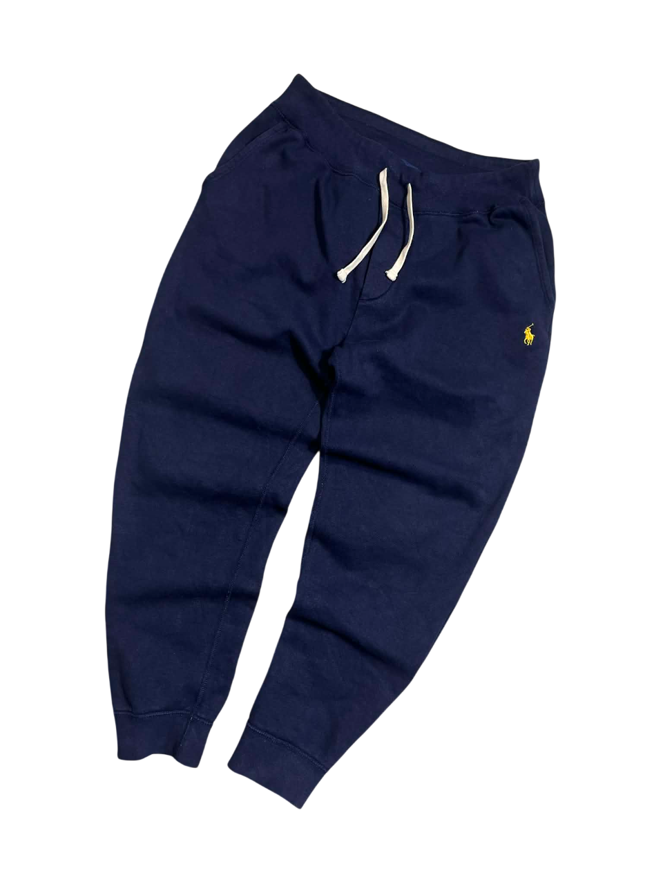 Sötétkék jogger nadrág hímzett logóval, streetwear stílusban, húzózsinóros derékkal.